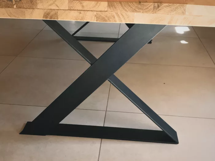 Un pied de table à manger croisé en acier noir