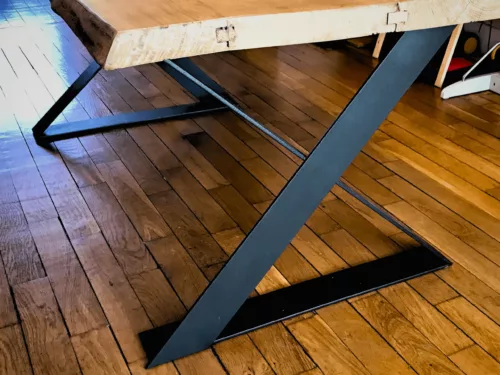 Des pieds de table croisés en acier dans un salon