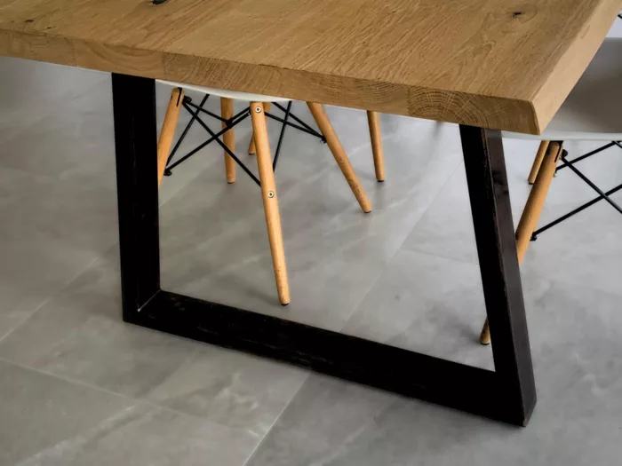 Un pied de table en acier noir, en forme de trapèze