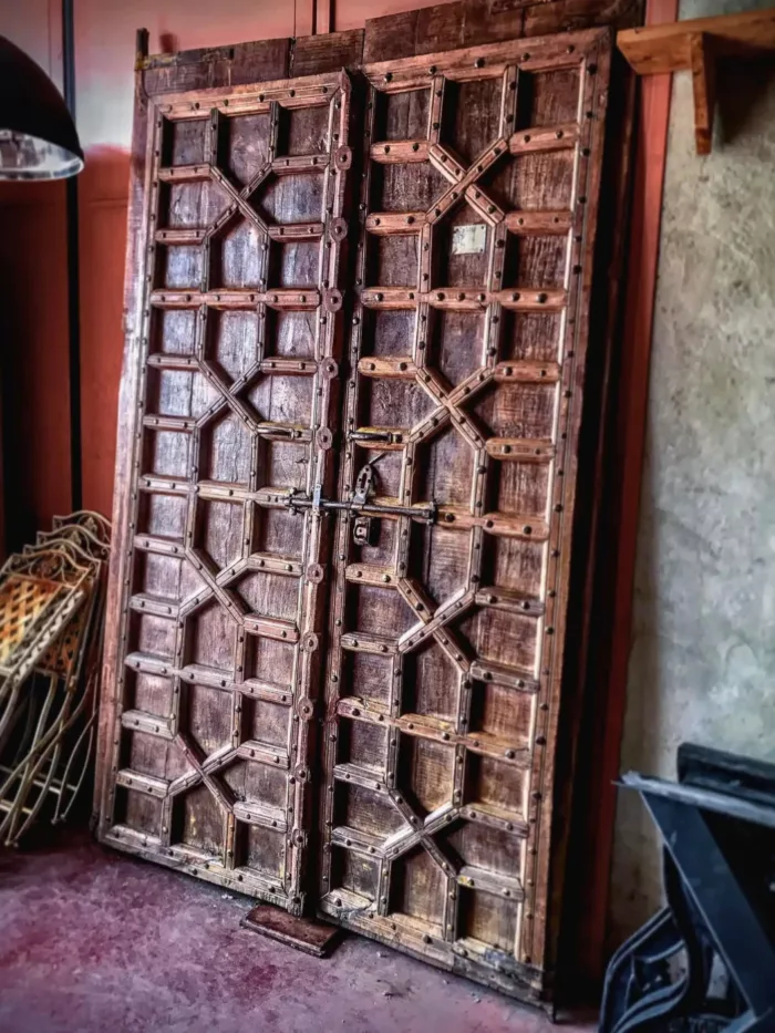 Des grandes portes indiennes de temple posées contre un mur