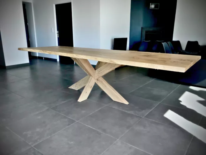 Une table avec un pied central Etoile en bois massif, dans un salon avec un carrelage gris foncé