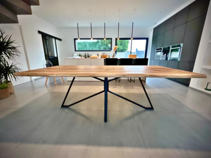 Une table à manger avec un pied graphique Spider en acier noir dans une salle à manger