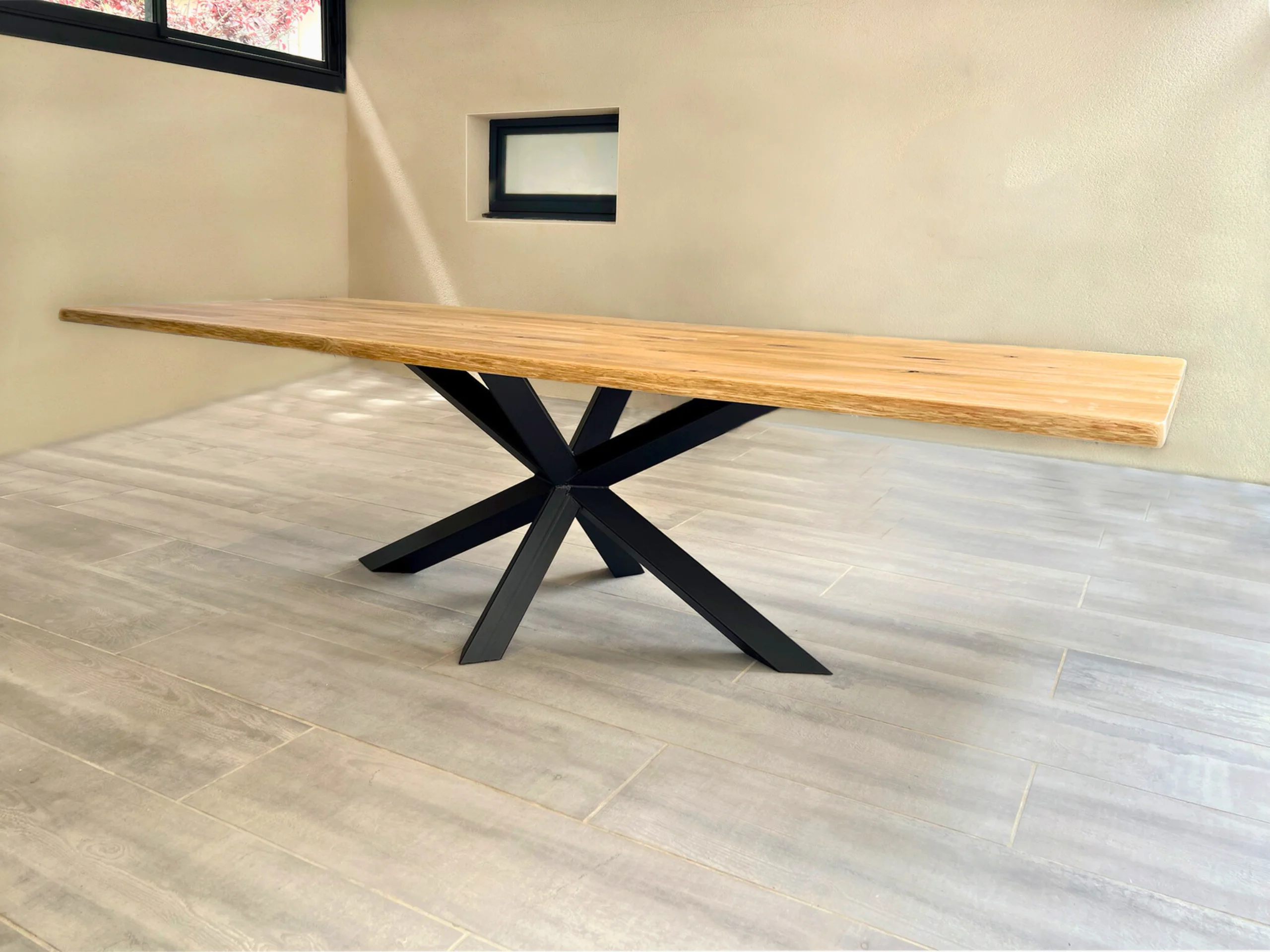 Une table en chêne avec un pied central Diamant en acier noir dans un salon clair