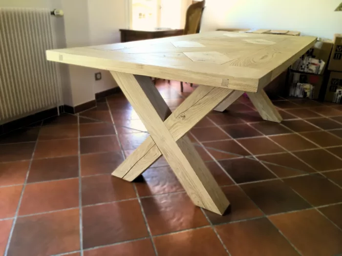 Une table avec un plateau en chêne et des pieds X