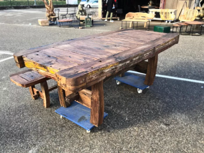 Une table en bois de bateau, avec un banc en bois de bateau, en extérieur