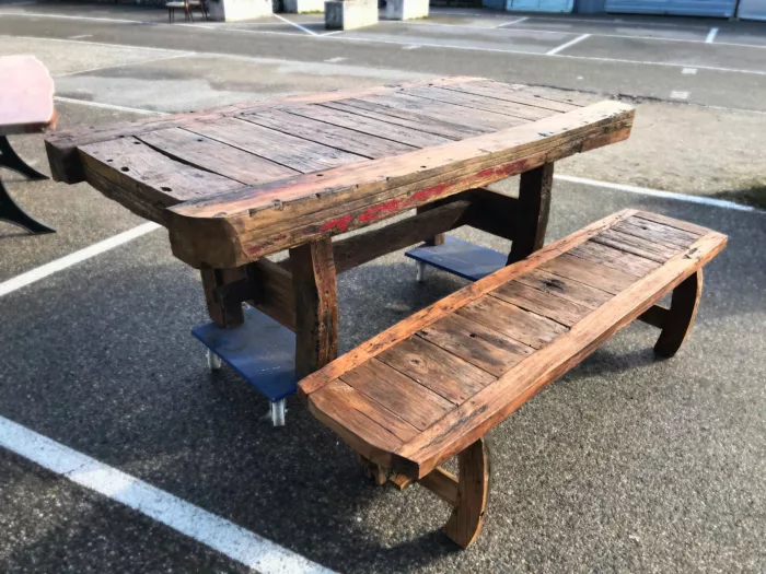 Une table en bois de bateau recyclé, avec un banc assorti