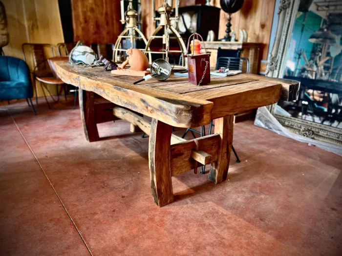 Un magasin avec une table de salle à manger en bois de bateau recyclé, avec des décorations