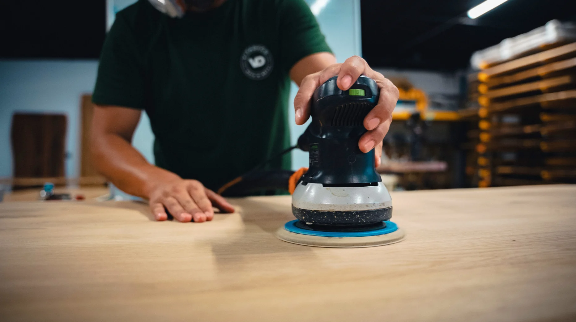 Dans un atelier de menuisier, le ponçage d'une table sur mesure