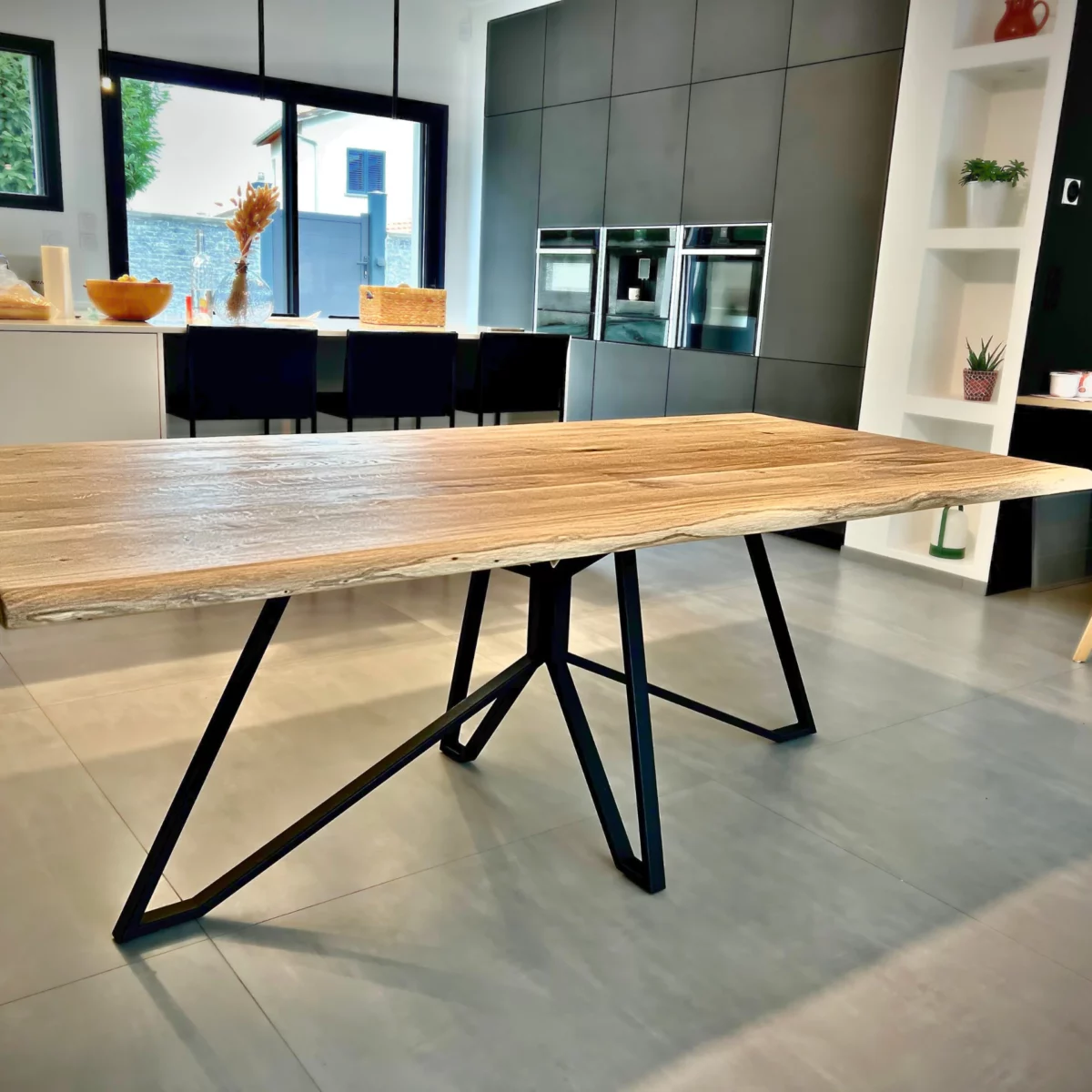 Une table en bois avec un pied de table central en acier Spider