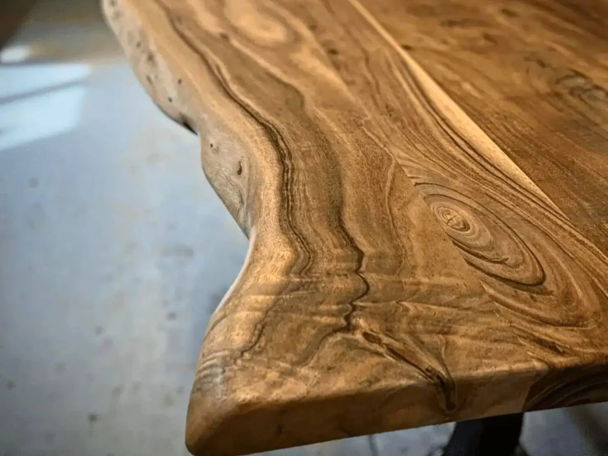 Un plateau de table à manger en acacia massif, avec des bords naturels irréguliers