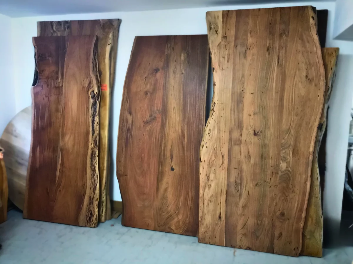 Des plateaux de table sur-mesure en acacia massif contre le mur d'un atelier