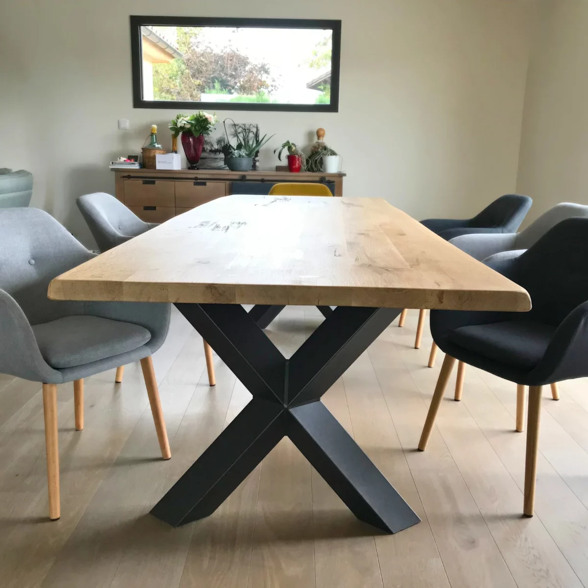 Une table à manger en bois massif avec des pieds croisés