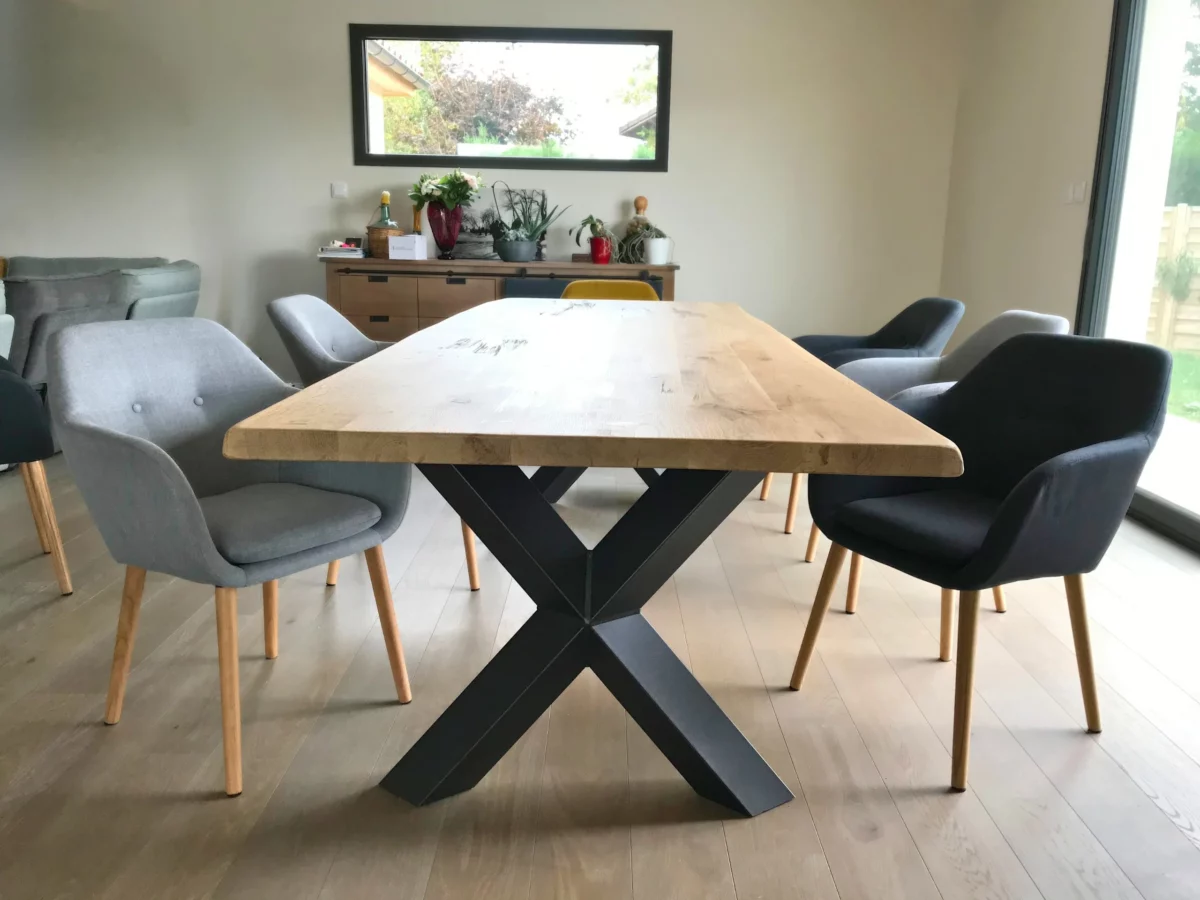 Une table à manger en bois massif avec des pieds croisés