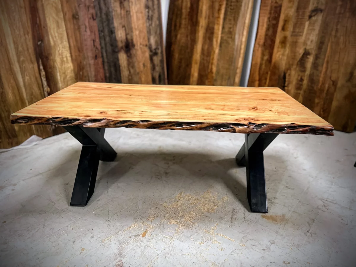 Une table basse avec des pieds métalliques croisés