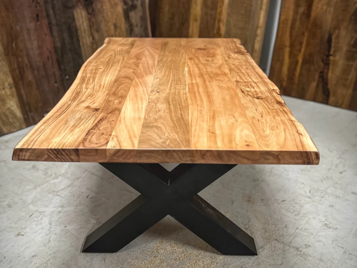 Une table basse avec des pieds en acier en forme de X, symbole de décoration intérieure artisanale