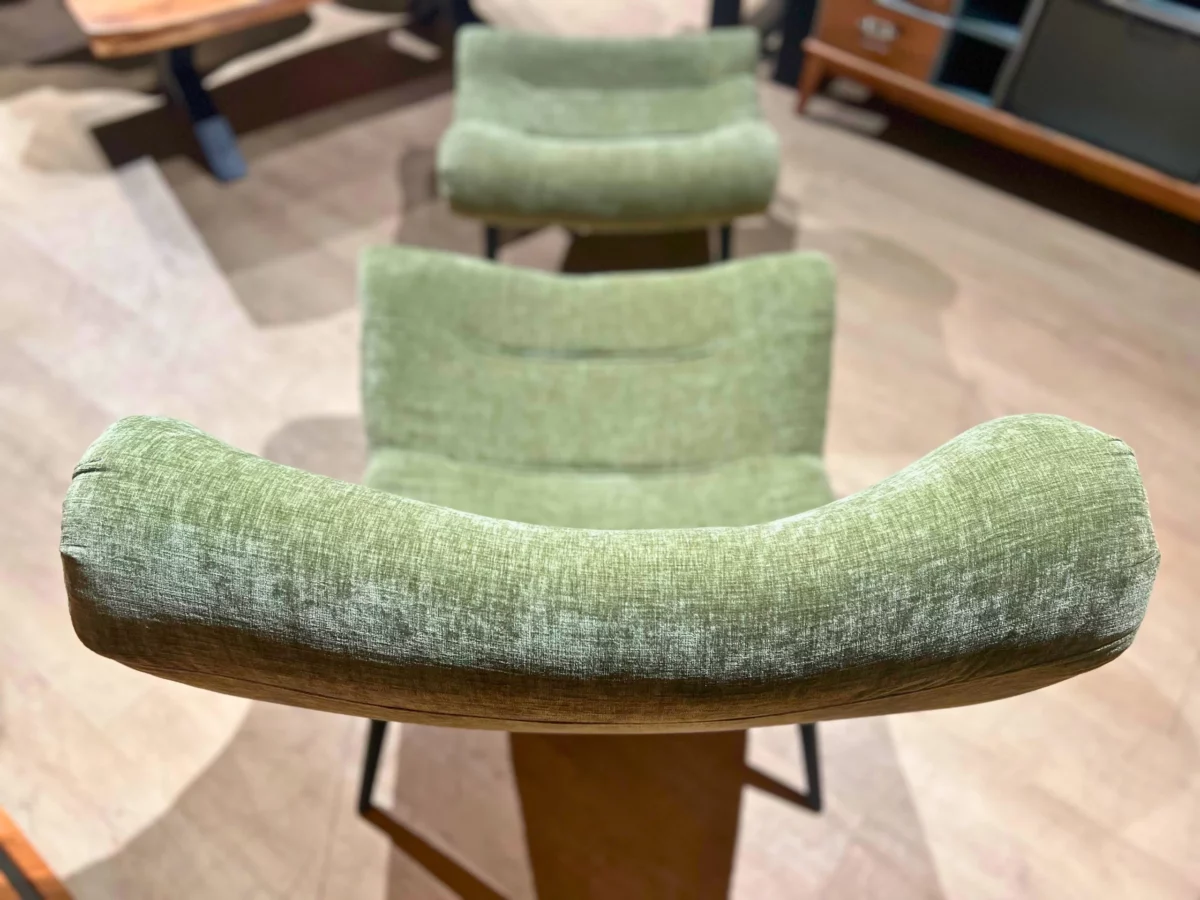 Le dossier d'un fauteuil en velours olive