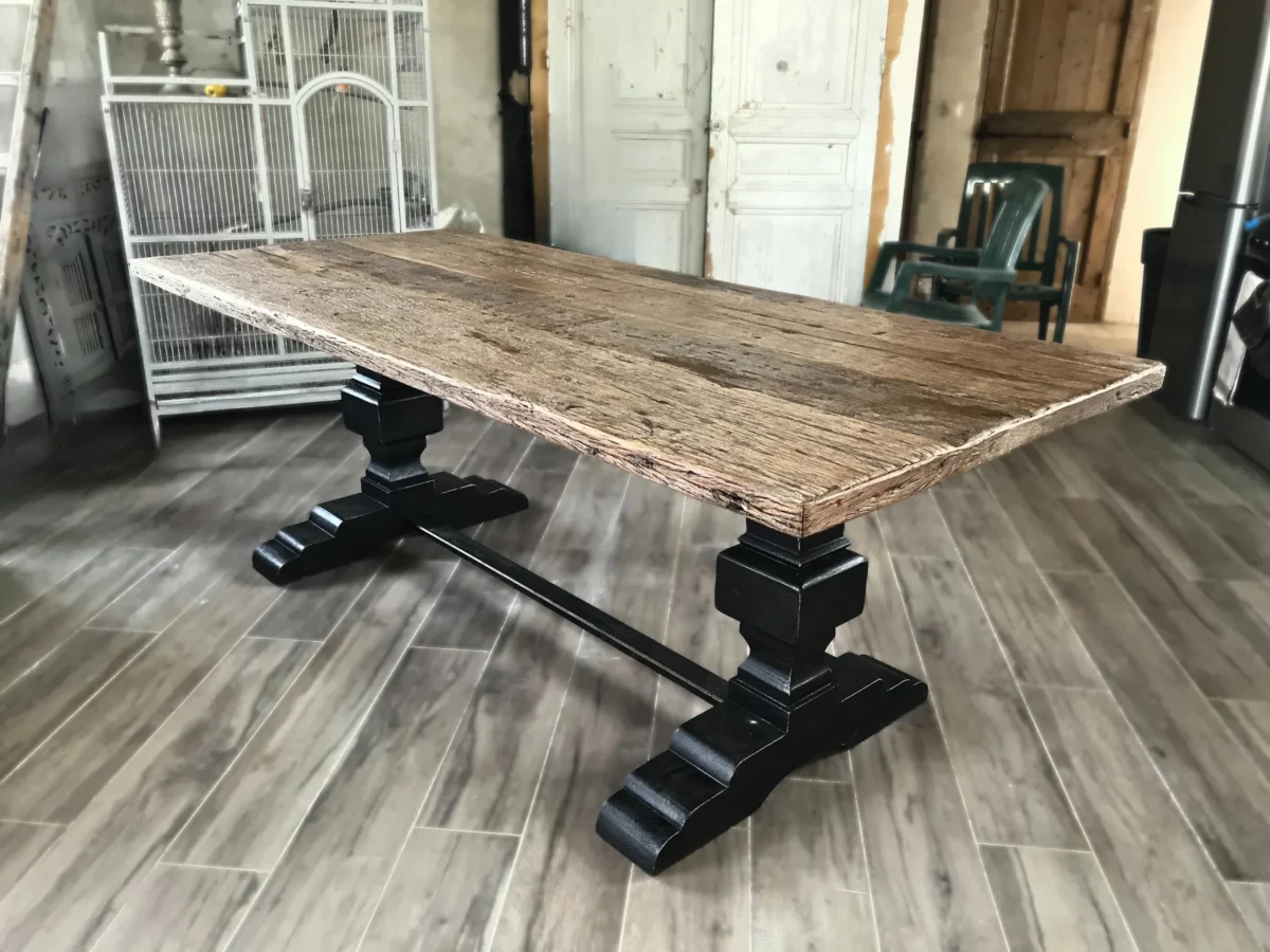 Une salle à manger avec une table dotée de pieds en bois style monastère