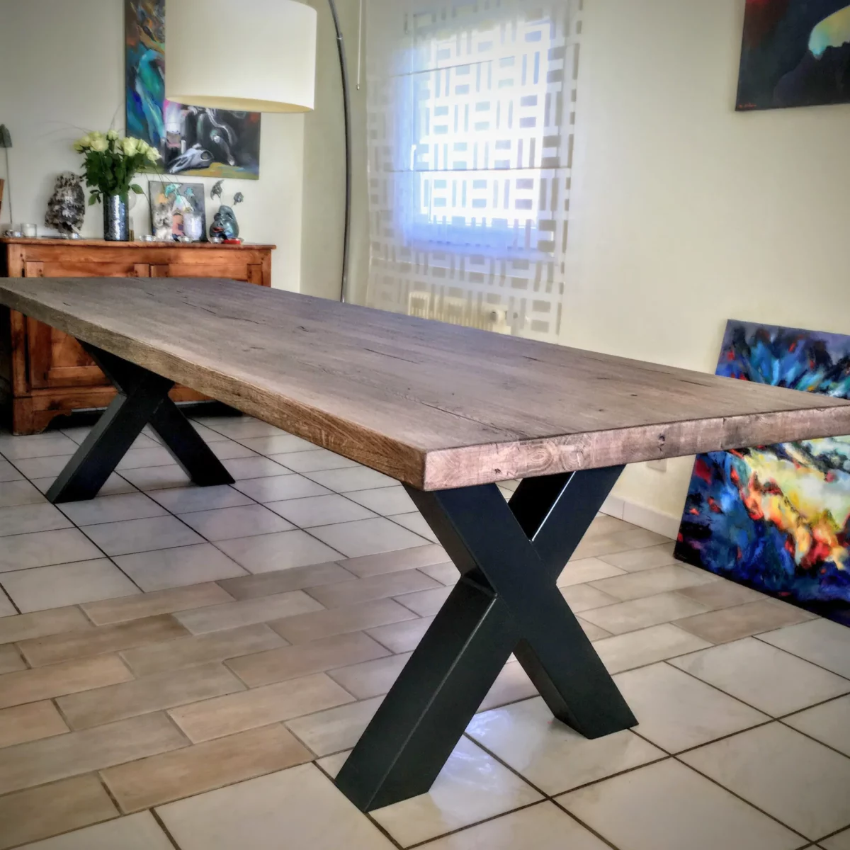 Une table de salle à manger avec un pied de table Croix en acier