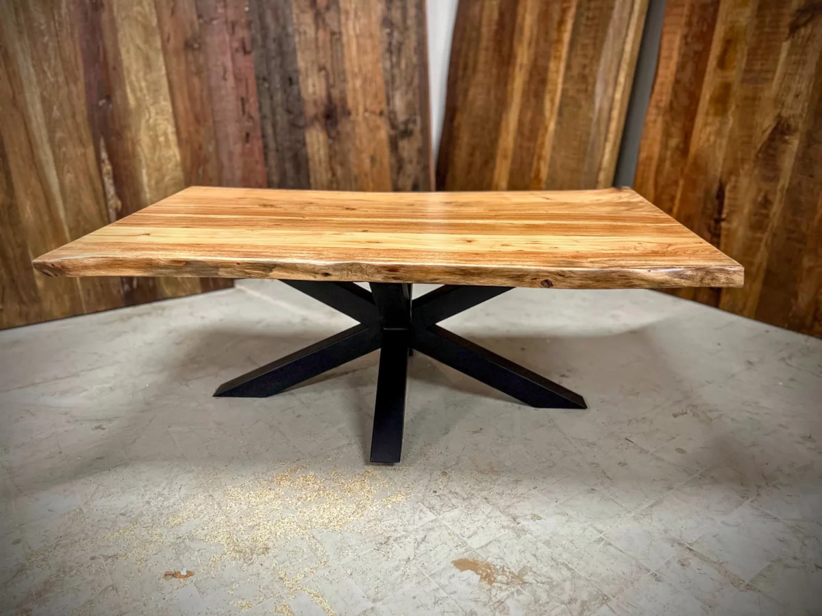 Une table basse avec un pied central en forme d'étoile