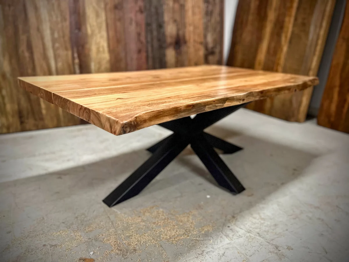 Une table basse avec un pied central dans un atelier de menuiserie