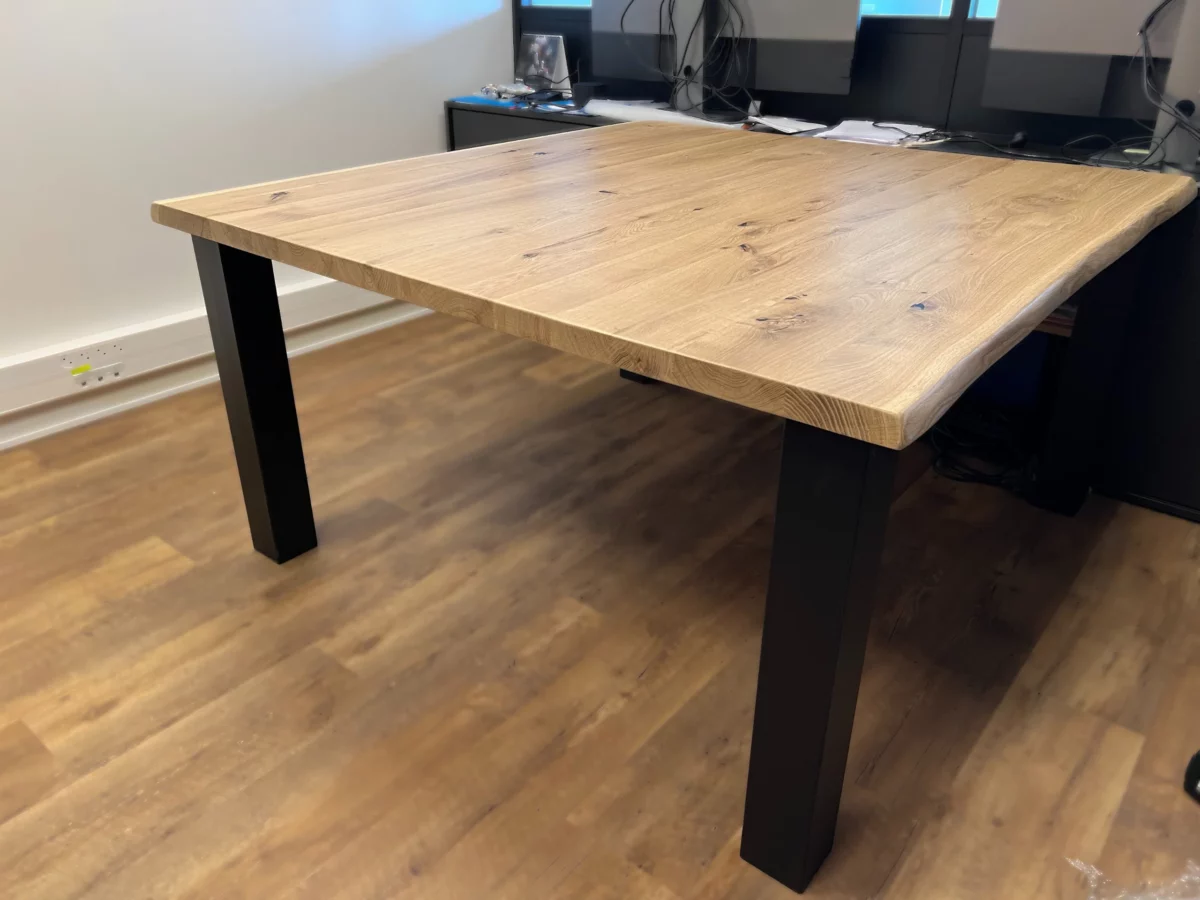 Une table en chêne massif avec des pieds de table droits en acier