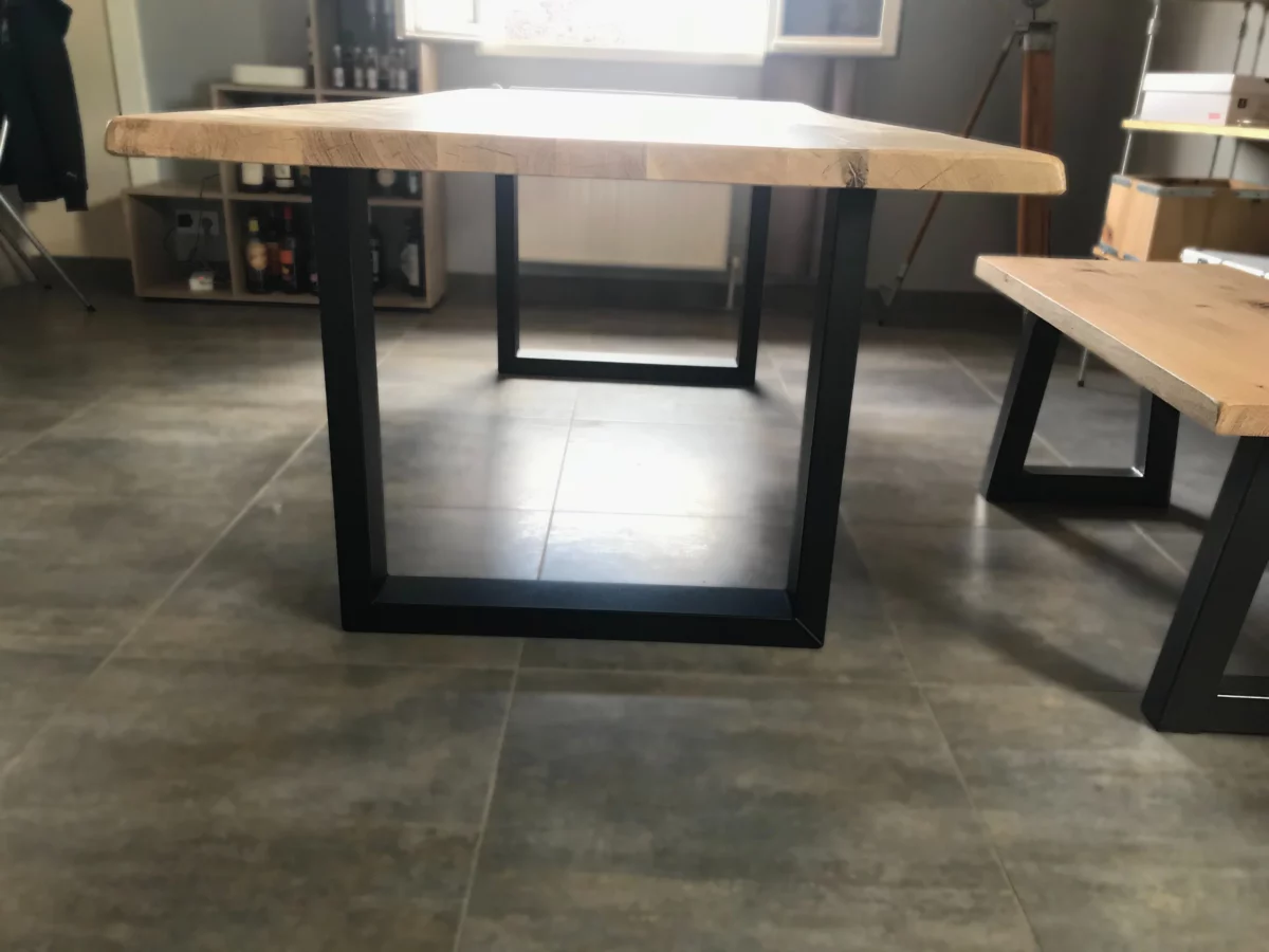 Une table à manger en bois et acier avec un banc dans un salon