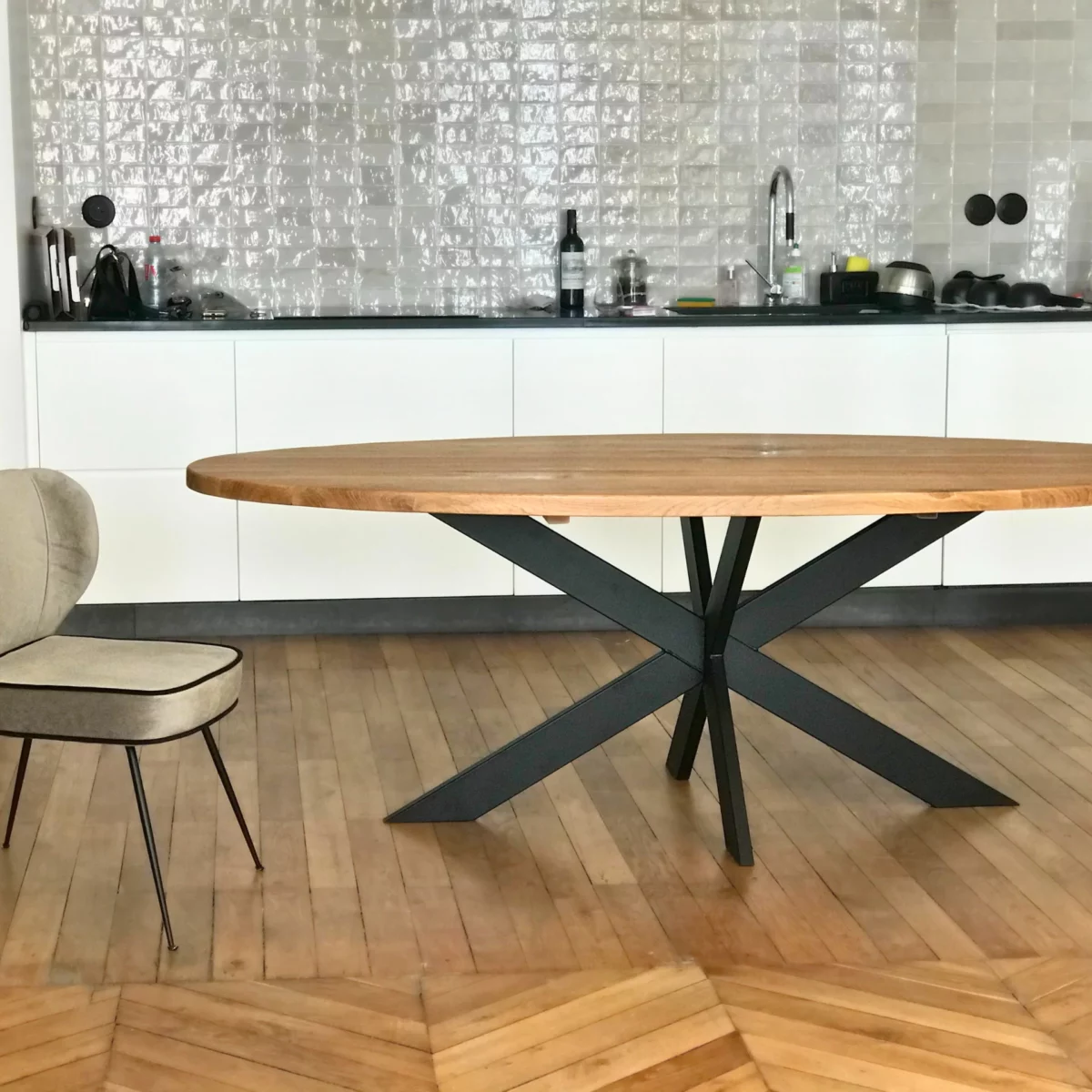 Une cuisine, avec une table en bois et acier industriel, avec un fauteuil