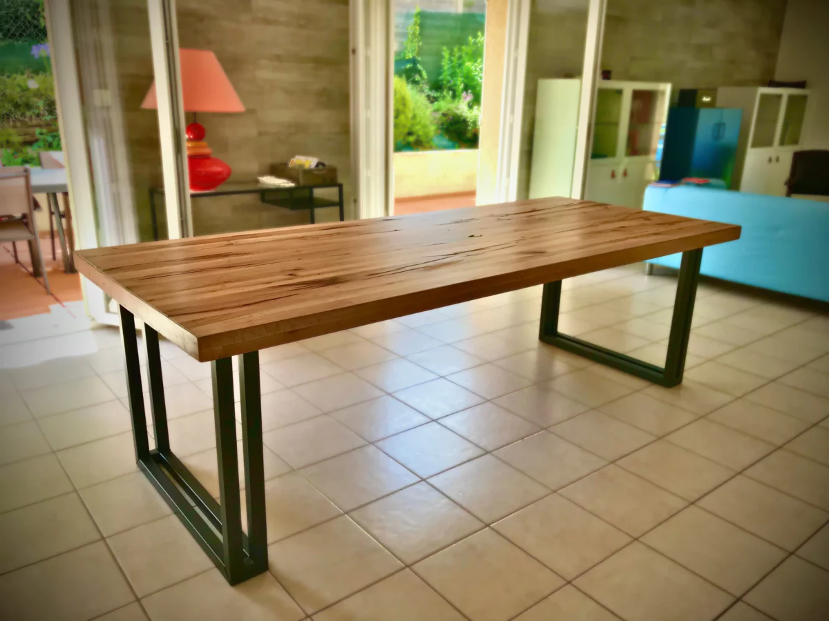 Une table à manger bois et acier avec des chaises en métal