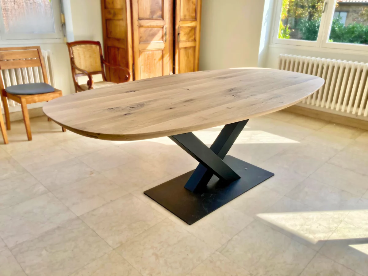 Une table à manger ovale avec un pied central en acier